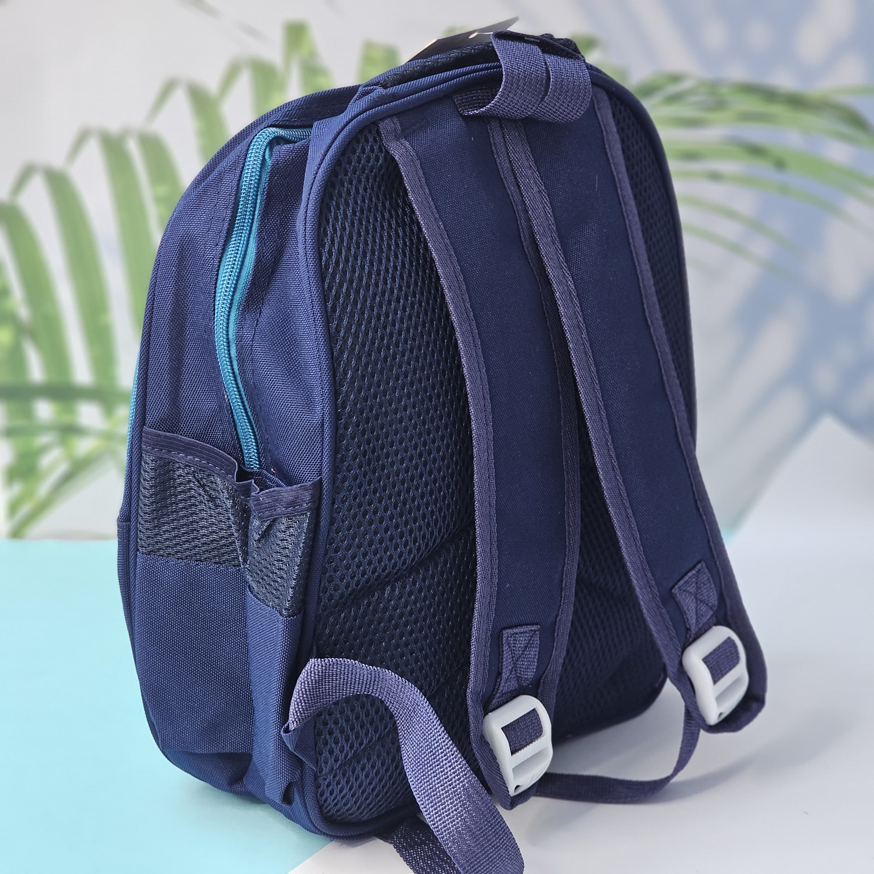 "Close-up of a Usmile Toys children's cartoon school backpack, designed in pink with a playful unicorn character on the front panel, and a matching pink water bottle in the side mesh pocket."